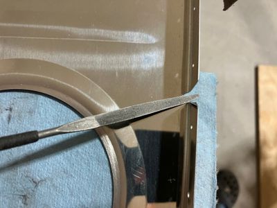 Using a half-round file to deburr.