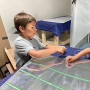 Apprentices insert rivets into the skin.