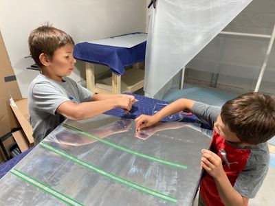 Apprentices insert rivets into the skin.